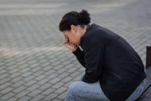 Side view of woman holding her head
