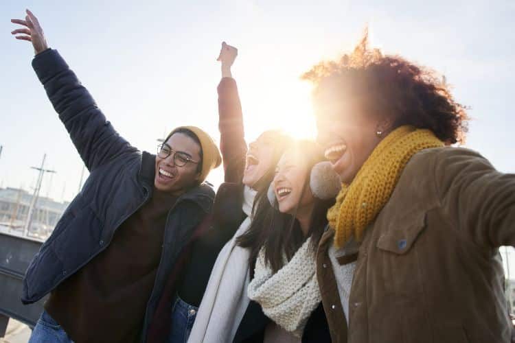 Group of excited young friends having fun together outdoors.