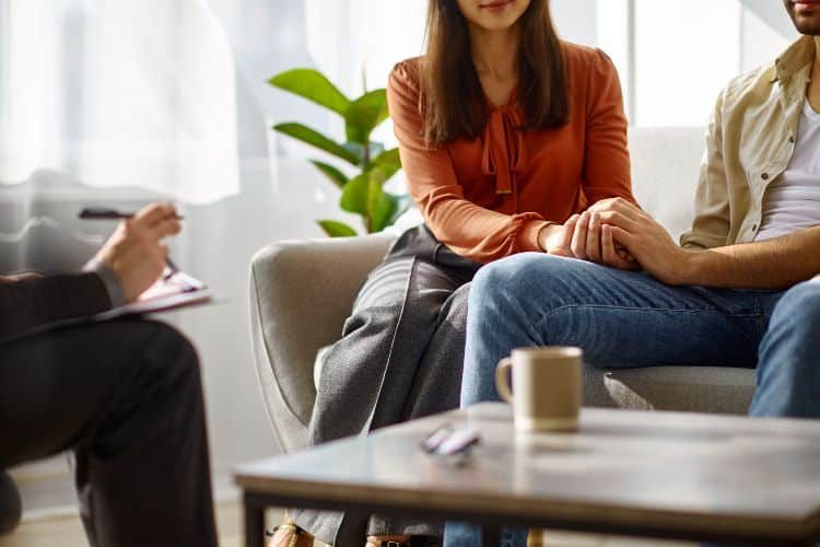 couple sitting in a therapist's office participating in family therapy